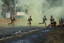 U.S. Marine Corps students with Company F, The Basic School, run towards a building during a platoon attack at Marine Corps Base Quantico, Virginia, Feb. 25, 2026. The purpose of the simulated platoon attacks was to introduce Marines to the fundamentals of Military Operations on Urban Terrain training, evaluate their leadership in high-stress environments, and develop them into confident, provisional rifle platoon commanders. (U.S. Marine Corps photo by Cpl. Joshua Barker)