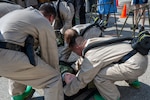 U.S. Air Force Lackland Medical Squadron-Randolph in-place patient decontamination Airmen receives a manikin during a decontamination training at Joint Base San Antonio-Randolph on Feb. 19, 2026. The concept of the decontamination tent was to bring the patient out of the tent and into the clinic free of hazardous chemicals. (U.S. Air Force photo by Senior Airman Jasmine Galloway)