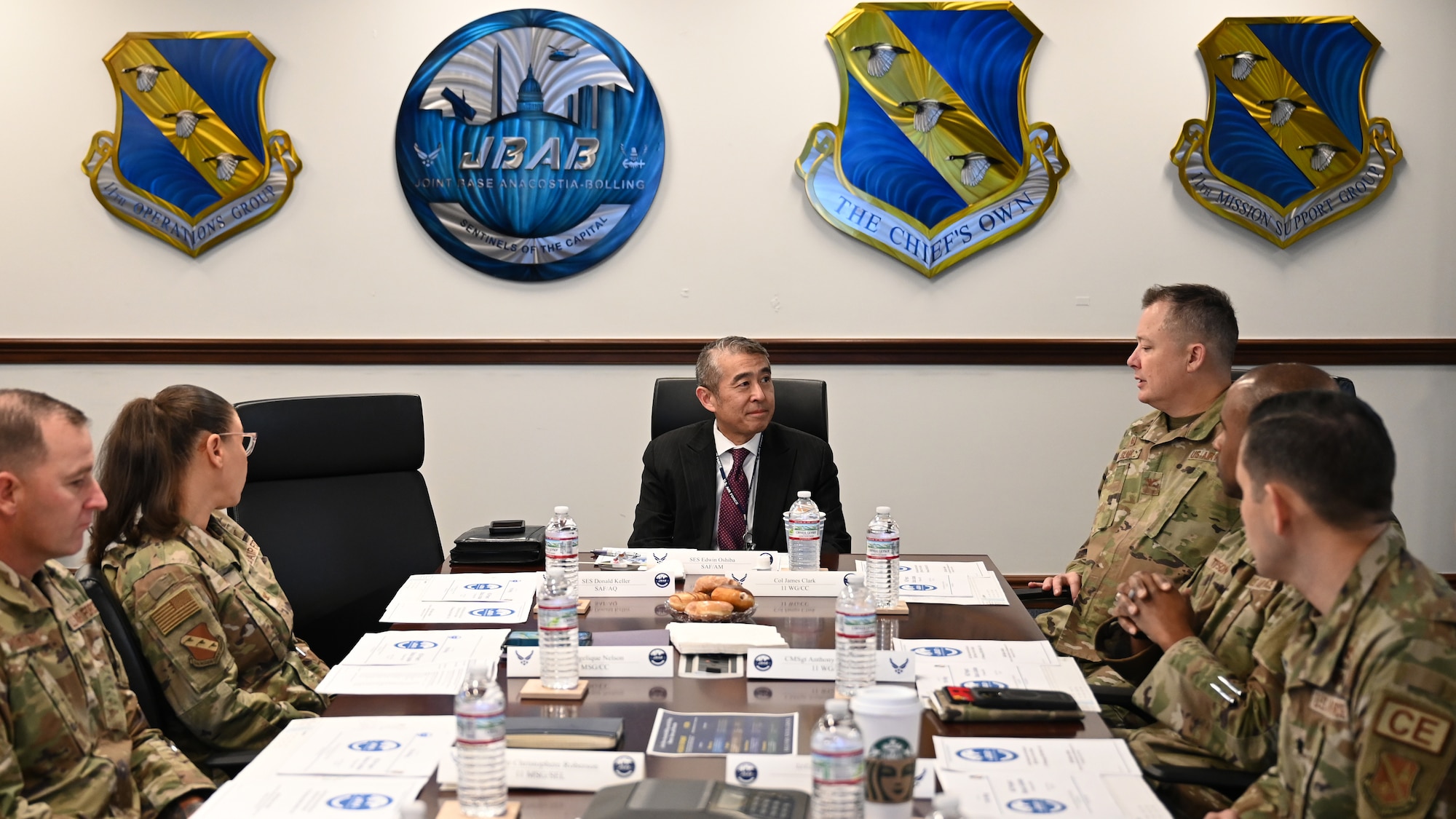 photo of Air Force service members sitting in a conference room with a senior executive service member