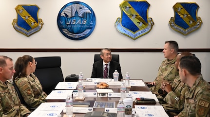 photo of Air Force service members sitting in a conference room with a senior executive service member