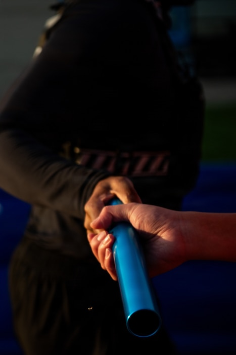 Close up of Airmen's hands exchanging a baton
