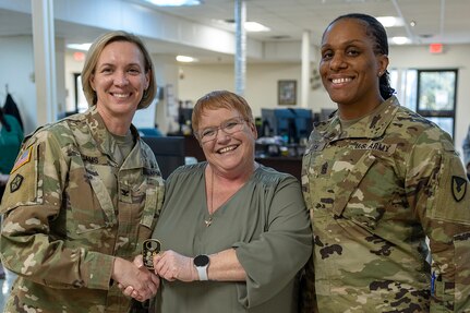 Col. Michelle M. Williams, U.S. Army Financial Management Command commander, and Command Sgt. Maj. Joy L. Allen, USAFMCOM senior enlisted advisor, present a commander’s challenge coin to Dawn Martin, USAFMCOM Fort Knox Army Military Pay Office quality review analyst, at Fort Knox, Ky., March 4, 2026. USAFMCOM’s leadership visited the Fort Knox AMPO during a major subordinate command update to the U.S. Army Materiel Command and thanked the employees for their hard work in supporting Soldiers and their families. (U.S. Army photo by Mark R. W. Orders-Woempner)