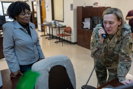 Col. Michelle M. Williams, U.S. Army Financial Management Command commander, talks with Fort McCoy Army Military Pay Office employees on the phone at Wendy Cherry, USAFMCOM Fort Knox AMPO chief listens at Fort Knox, Ky., March 4, 2026. USAFMCOM’s leadership visited the Fort Knox AMPO during a major subordinate command update to the U.S. Army Materiel Command and thanked the employees for their hard work in supporting Soldiers and their families. (U.S. Army photo by Mark R. W. Orders-Woempner)