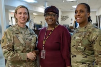Col. Michelle M. Williams, U.S. Army Financial Management Command commander, and Command Sgt. Maj. Joy L. Allen, USAFMCOM senior enlisted advisor, present a commander’s challenge coin to Sharon Pettaway, USAFMCOM Fort Knox Army Military Pay Office deputy chief, at Fort Knox, Ky., March 4, 2026. USAFMCOM’s leadership visited the Fort Knox AMPO during a major subordinate command update to the U.S. Army Materiel Command and thanked the employees for their hard work in supporting Soldiers and their families. (U.S. Army photo by Mark R. W. Orders-Woempner)