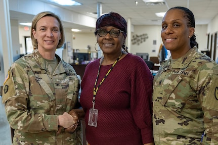 Col. Michelle M. Williams, U.S. Army Financial Management Command commander, and Command Sgt. Maj. Joy L. Allen, USAFMCOM senior enlisted advisor, present a commander’s challenge coin to Sharon Pettaway, USAFMCOM Fort Knox Army Military Pay Office deputy chief, at Fort Knox, Ky., March 4, 2026. USAFMCOM’s leadership visited the Fort Knox AMPO during a major subordinate command update to the U.S. Army Materiel Command and thanked the employees for their hard work in supporting Soldiers and their families. (U.S. Army photo by Mark R. W. Orders-Woempner)