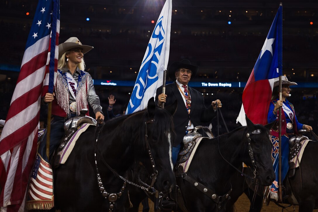 Houston Livestock Show and Rodeo staff ride into the main rodeo arena during the Grand Entry on Armed Forces Appreciation Day in Houston, March 4, 2026. Armed Forces Appreciation Day honored nearly 4,000 military personnel and veterans, including a joint service enlistment ceremony for approximately 500 recruits. (U.S. Marine Corps photo by SSgt. Ethan M. LeBlanc)