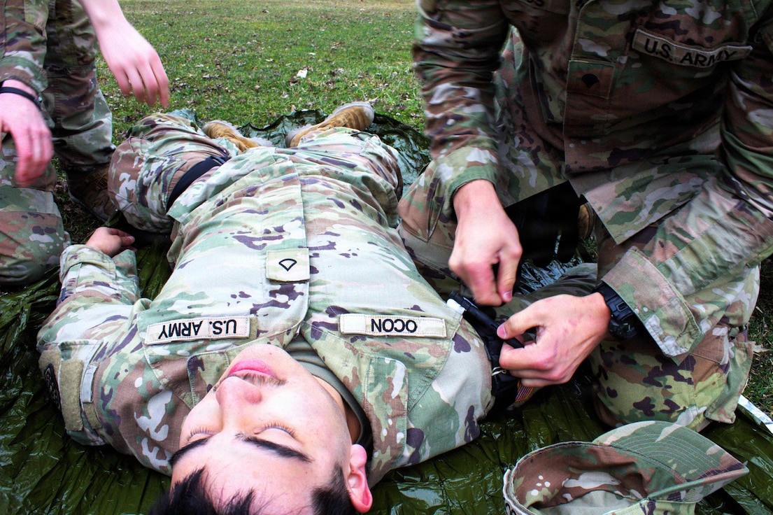 Spc Jaden Simos applies a tourniquet to Pfc. Joel Ocon.