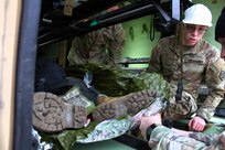 Sgt Tomas Walsh, a squad leader with 708th Medical Company Ground Ambulance, shows medics how to properly secure a litter inside their ambulance so it does not slide around while they are driving.