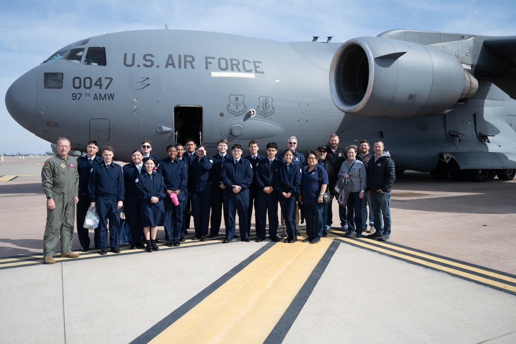 Junior Reserve Officers' Training Corps cadets from Detachment OK-20061 and local school board members pose for a group photo in front of a C-17 Globemaster III aircraft at Altus Air Force Base, Oklahoma, March 3, 2026. The C-17 is a strategic airlifter designed to deliver troops and cargo directly into austere airfields worldwide. (U.S. Air Force photo by Airman 1st Class Nathan Langston)