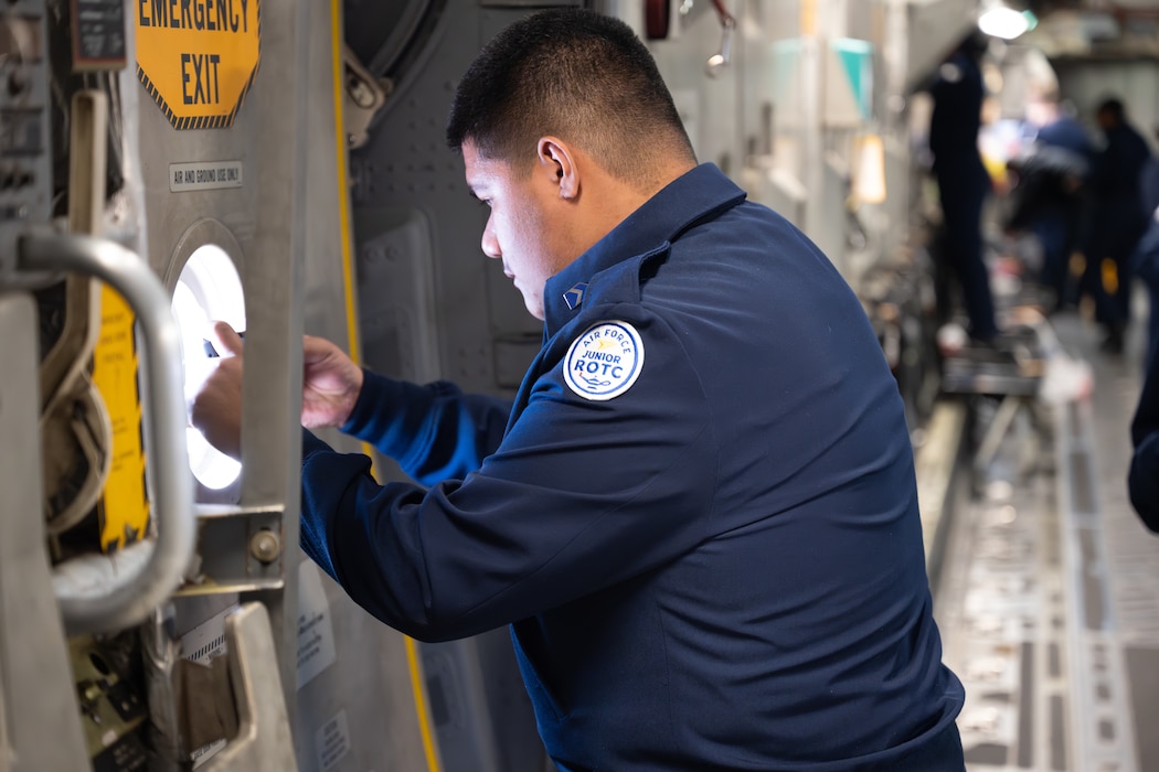 A Junior Reserve Officers' Training Corps cadet from Detachment OK-20061 takes a photo aboard a C-17 Globemaster III aircraft over Oklahoma, March 3, 2026. Incentive flights provide selected cadets an orientation experience to observe aircrew roles and the C-17’s airlift mission. (U.S. Air Force photo by Airman 1st Class Nathan Langston)