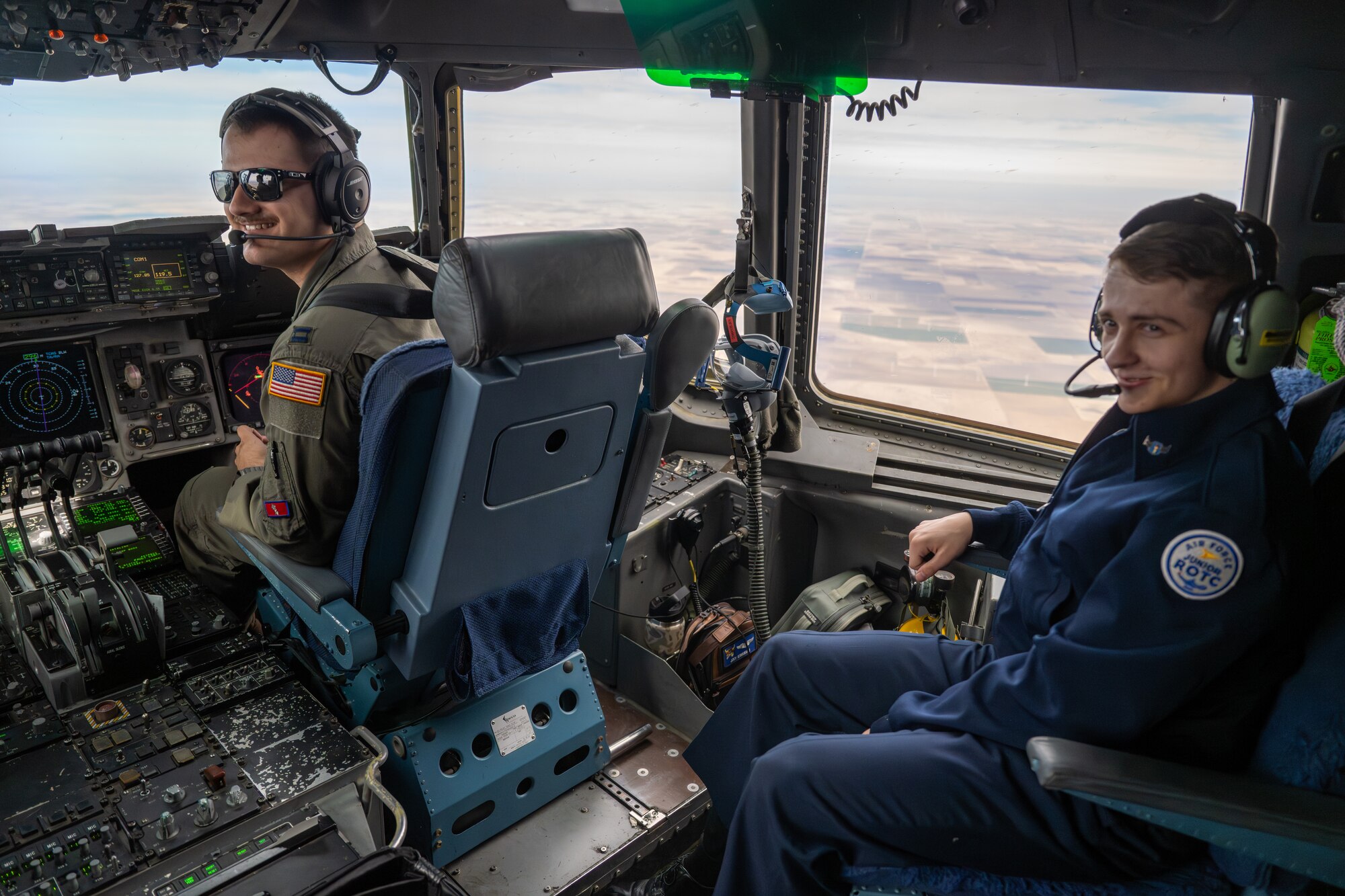 U.S. Air Force Capt. Michael Kavanagh, 58th Airlift Squadron formal training unit instructor pilot, speaks with a Junior Reserve Officers' Training Corps cadet from Detachment OK-20061 during an incentive flight over Oklahoma, March 3, 2026. The flight provided cadets an opportunity to learn about Air Force airlift operations and career paths from assigned aircrew members. (U.S. Air Force photo by Airman 1st Class Nathan Langston)