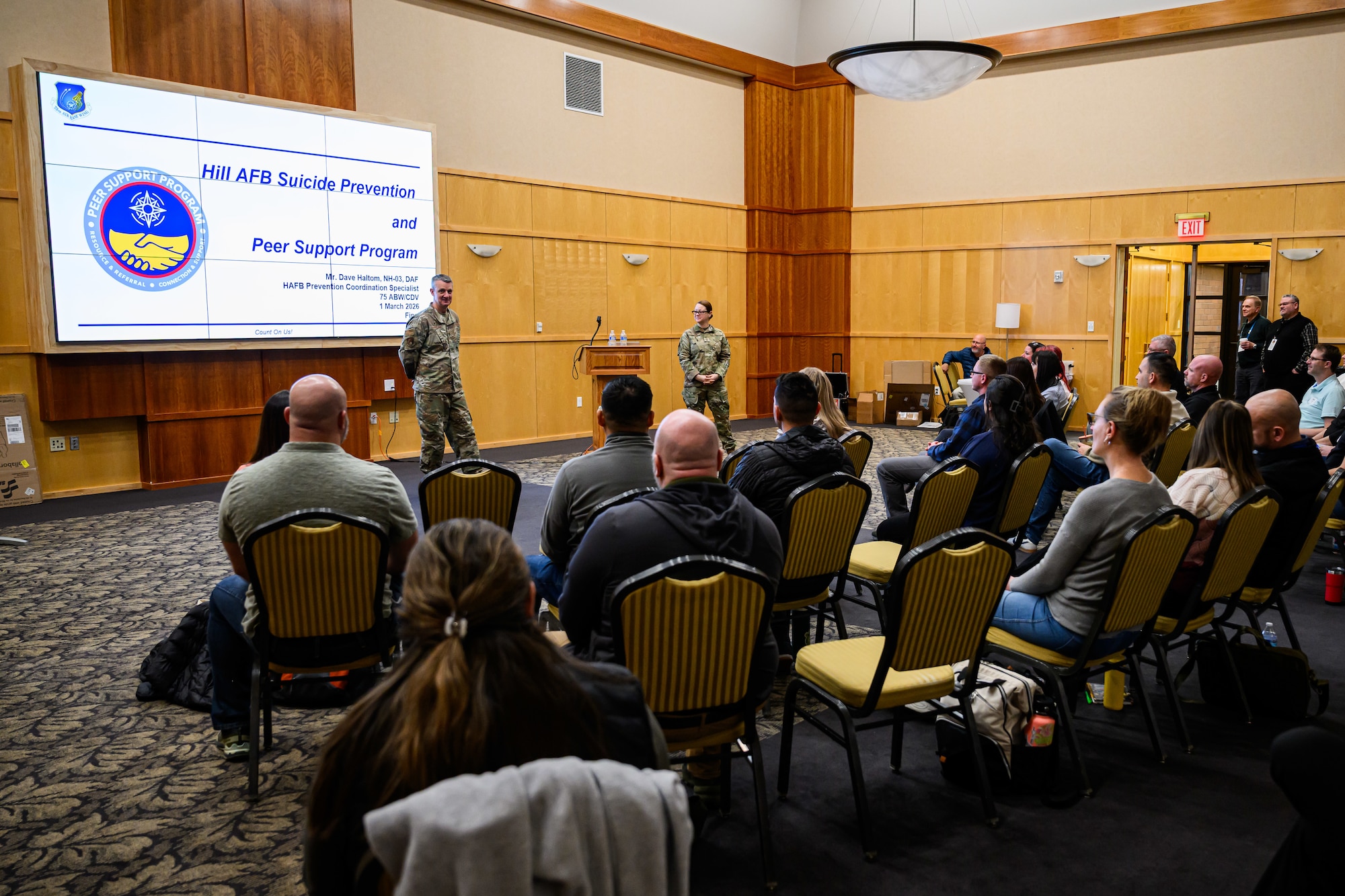 Col. Dan Cornelius stands in front of a group providing welcoming remarks.