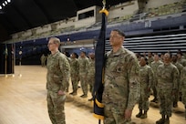 U.S. Army Sgt. 1st Class Kevin Whitehead (left) and Lt. Col. Andrew Garwitz (right), both with the D.C. National Guard, stand in front of the formation with the brigade colors during the 260th Special Purpose Brigade activation ceremony at the activation ceremony at the D.C. Armory in Washington, D.C., March 7, 2026.