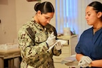 Hospitalman Apprentice Gabriela Avecillas, left, and Hospital Corpsman 3rd Class Melissa Avila Cruz participate in a Forensic Healthcare Program training course at Navy Medicine Readiness and Training Command Twentynine Palms on Nov. 18, 2025. The training prepares hospital corpsmen to assist providers during sensitive medical examinations while ensuring proper evidence handling and patient care, supporting force readiness. (U.S. Navy photo by Christopher Jones, NMRTC / Naval Hospital Twentynine Palms public affairs officer)