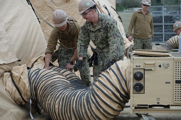 U.S. Navy Seabees assigned to Naval Mobile Construction Battalion (NMCB)-1, Port Hueneme, CA, inspect and ensure air conditioning units are operational during an Expeditionary Medical Facility Kilo training at the Naval Expeditionary Medicine Warfighter Development Center, Camp Pendleton, California, Feb. 9–18, 2026. Environmental control systems are critical to maintaining safe working conditions for patients and medical staff. (U.S. Navy photo by Petty Officer 2nd Class Leandra Mojica)