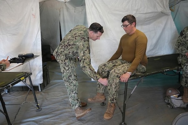 A medical staff with Expeditionary Medical Facility (EMF) Kilo, based out of Navy Medicine Readiness and Training Command Camp Lejeune, North Carolina, conducts a medical exam on a simulated patient during an EMF training at the Naval Expeditionary Medicine Warfighter Development Center (NEMWDC), Camp Pendleton, California, Feb. 9–18, 2026. Scenario-based training strengthens clinical assessment skills and prepares the EMF Kilo personnel to operate in deployed medical environments. (U.S. Navy photo by Petty Officer 2nd Class Leandra Mojica)