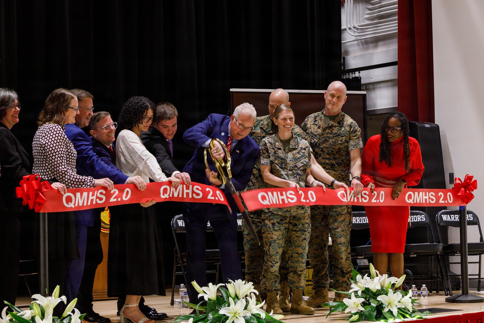 U.S. Marines and Ceremony Committee Members conduct the cutting of the ribbon during the grand opening of the Quantico Middle/High School on Marine Corps Base Quantico, Virginia, March 9, 2026. This event was held to dedicate the new Quantico Middle/High School building that was recently built, shining a light on a structure that will become a staple of MCB Quantico’s history. (U.S. Marine Corps photo by Lance Cpl. Lynsee Avila-Ramirez)