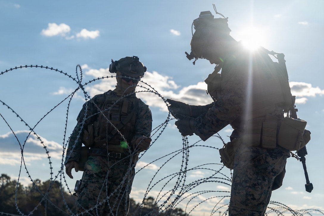 U.S. Marine Corps Cpl. Brady Walter, left, and Pfc. Samuel Lopezavila, both combat engineers with 3rd Battalion, 2nd Marine Regiment, 24th Marine Expeditionary Unit, set up concertina wire during the MEU’s certification exercise at Marine Corps Outlying Landing Field Atlantic, North Carolina, Feb. 23, 2026. CERTEX is a land-based pre-deployment exercise that enhances the integration and collective capability of the Marine Air-Ground Task Force while providing the 24th MEU with an opportunity to train and execute operations in austere and urban environments. (U.S. Marine Corps photo by Sgt. Daniel Childs)