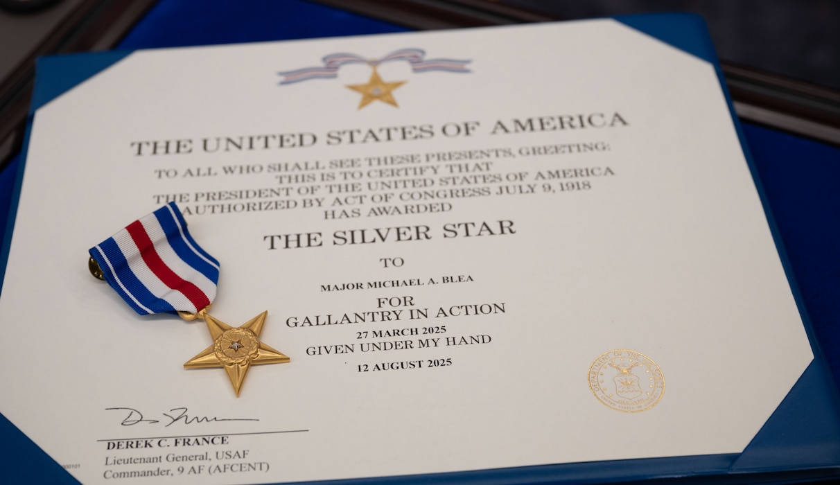 A silver star certificate rests on a table