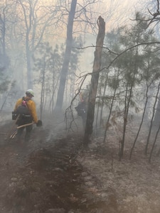 Oklahoma National Guard wildland firefighters partrol a fireline searching for hotspots during fire fighting operations near Talihinia, Oklahoma, Feb. 27, 2026.