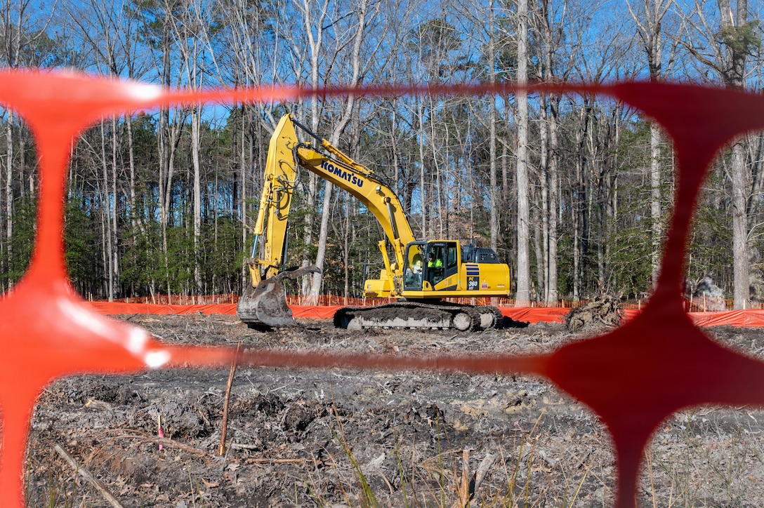 Photo showing heavy equipment sitting on a piece of land that it is clearing out.