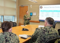 JOINT BASE SAN ANTONIO-FORT SAM HOUSTON – (March 4, 2026) – U.S. Navy Lt. Cmdr. Loreli Owens, director for Administration, Naval Medical Research Unit (NAMRU) San Antonio, briefs Capt. Kris Hodapp, deputy Corps Chief, Medical Service Corps (MSC) and Capt. Bryan Pyle, MSC Policy and Practice officer, during a visit to NAMRU San Antonio at the Battlefield Health and Trauma Research Institute (BHT). During the visit, Hodapp and Pyle toured research laboratories at BHT and the Tri-Service Research Laboratory and conducted independent record reviews with MSC officers. Additionally, they gave a State of the MSC briefing with emphasis on Navy Medicine’s North Star and Lines of Effort. Other areas of briefing included career progression, community values, manpower, promotion trends, and maintaining accuracy of military records. The MSC mission is to provide specialized healthcare, administrative, and scientific support to Naval forces, maximizing operational readiness and optimizing the "human weapon system". Comprised of professionals in clinical, scientific, and administrative fields, the MSC supports Navy Medicine’s mission to deliver manned, trained, and equipped medical units to the Fleet, Fleet Marine Force, and Joint Forces. NAMRU San Antonio, part of Navy Medicine Research & Development, conducts gap-driven combat casualty care, craniofacial, and directed energy research in support of Navy, Marine Corps and joint U.S. warfighter health readiness and lethality while engaged in routine and expeditionary operations. (Navy Photo by Burrell Parmer, NAMRU San Antonio Public Affairs/Released)