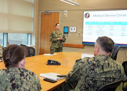 JOINT BASE SAN ANTONIO-FORT SAM HOUSTON – (March 4, 2026) – U.S. Navy Lt. Cmdr. Loreli Owens, director for Administration, Naval Medical Research Unit (NAMRU) San Antonio, briefs Capt. Kris Hodapp, deputy Corps Chief, Medical Service Corps (MSC) and Capt. Bryan Pyle, MSC Policy and Practice officer, during a visit to NAMRU San Antonio at the Battlefield Health and Trauma Research Institute (BHT). During the visit, Hodapp and Pyle toured research laboratories at BHT and the Tri-Service Research Laboratory and conducted independent record reviews with MSC officers. Additionally, they gave a State of the MSC briefing with emphasis on Navy Medicine’s North Star and Lines of Effort. Other areas of briefing included career progression, community values, manpower, promotion trends, and maintaining accuracy of military records. The MSC mission is to provide specialized healthcare, administrative, and scientific support to Naval forces, maximizing operational readiness and optimizing the "human weapon system". Comprised of professionals in clinical, scientific, and administrative fields, the MSC supports Navy Medicine’s mission to deliver manned, trained, and equipped medical units to the Fleet, Fleet Marine Force, and Joint Forces. NAMRU San Antonio, part of Navy Medicine Research & Development, conducts gap-driven combat casualty care, craniofacial, and directed energy research in support of Navy, Marine Corps and joint U.S. warfighter health readiness and lethality while engaged in routine and expeditionary operations. (Navy Photo by Burrell Parmer, NAMRU San Antonio Public Affairs/Released)