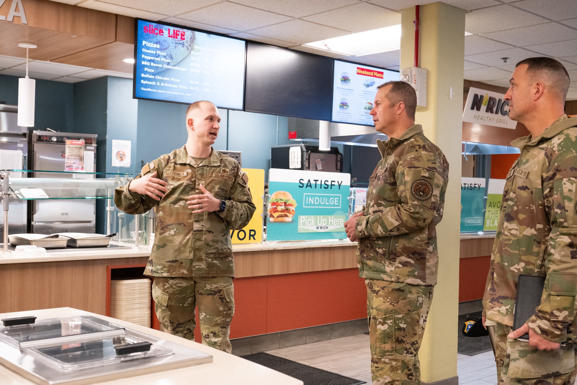 Tech. Sgt. Montana McCormick (left) speaks to Eight Air Force leadership inside a dining facility.
