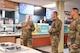 Tech. Sgt. Montana McCormick (left) speaks to Eight Air Force leadership inside a dining facility.