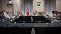 Airmen and civic leaders sit together at a table.