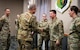 Maj. Gen. Ty Neuman (left) coins Staff Sgt.
Joseph Johnson (right) via a handshake.