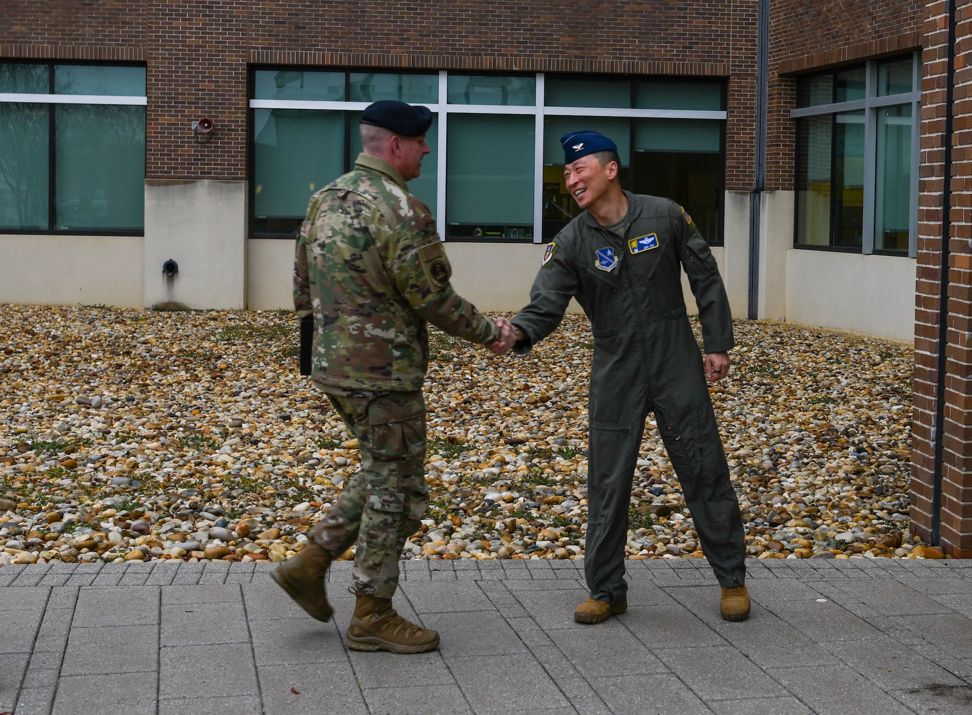 A general greets a chief outside.