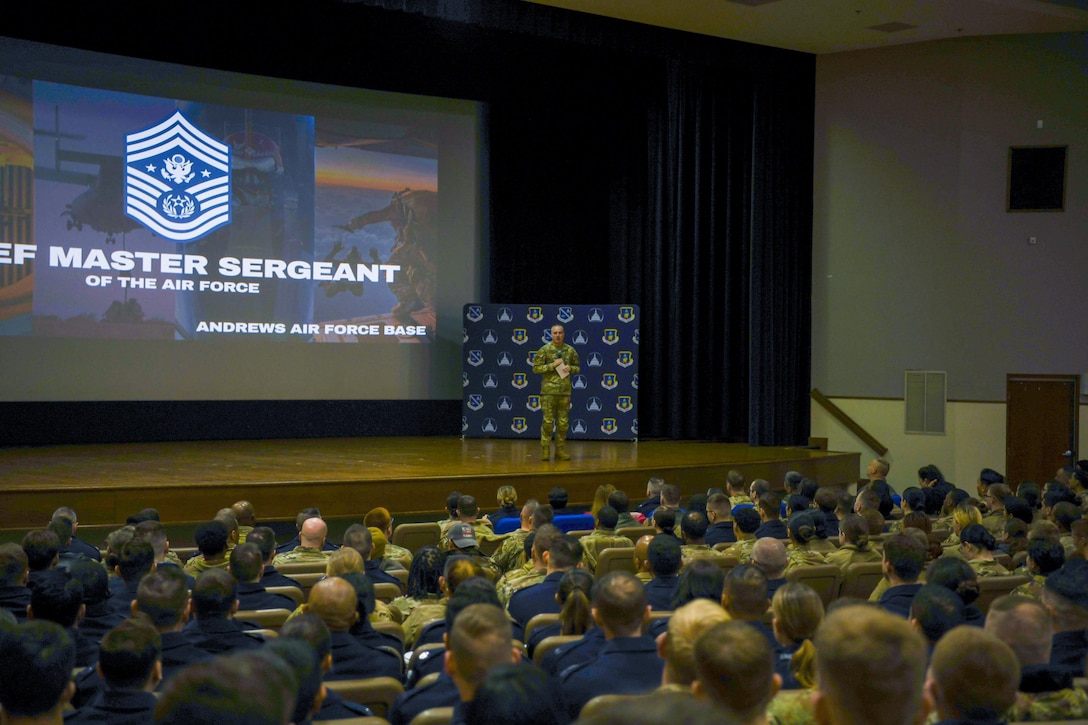 Airman speaks to crowd of troops.