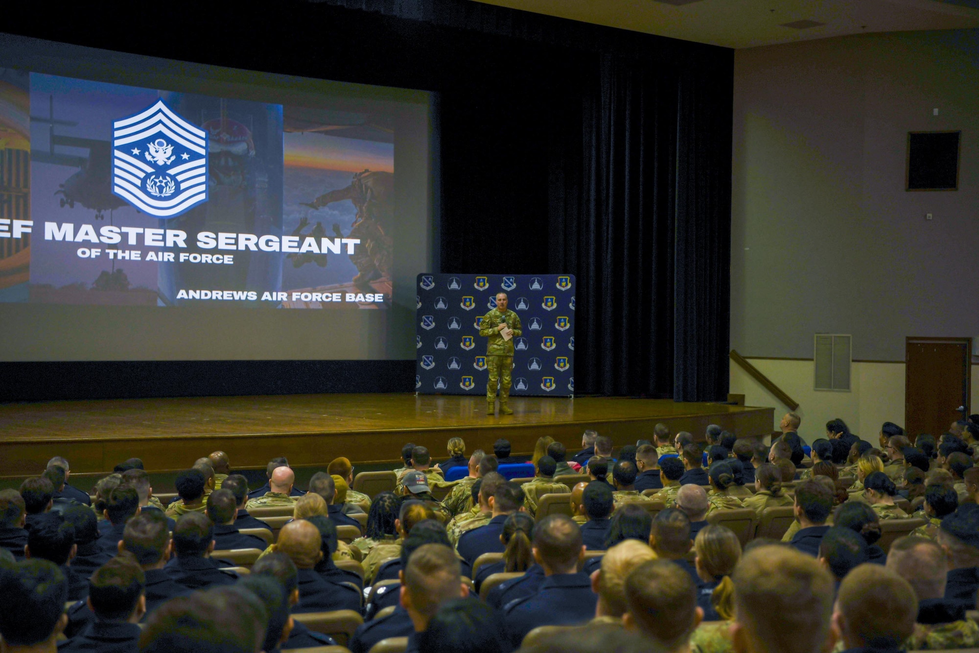 Airman speaks to crowd of troops.