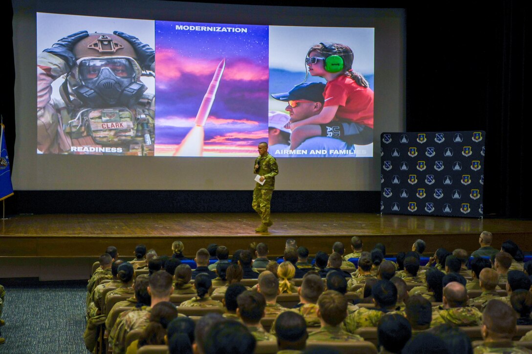 Airman speaks to crowd of troops.