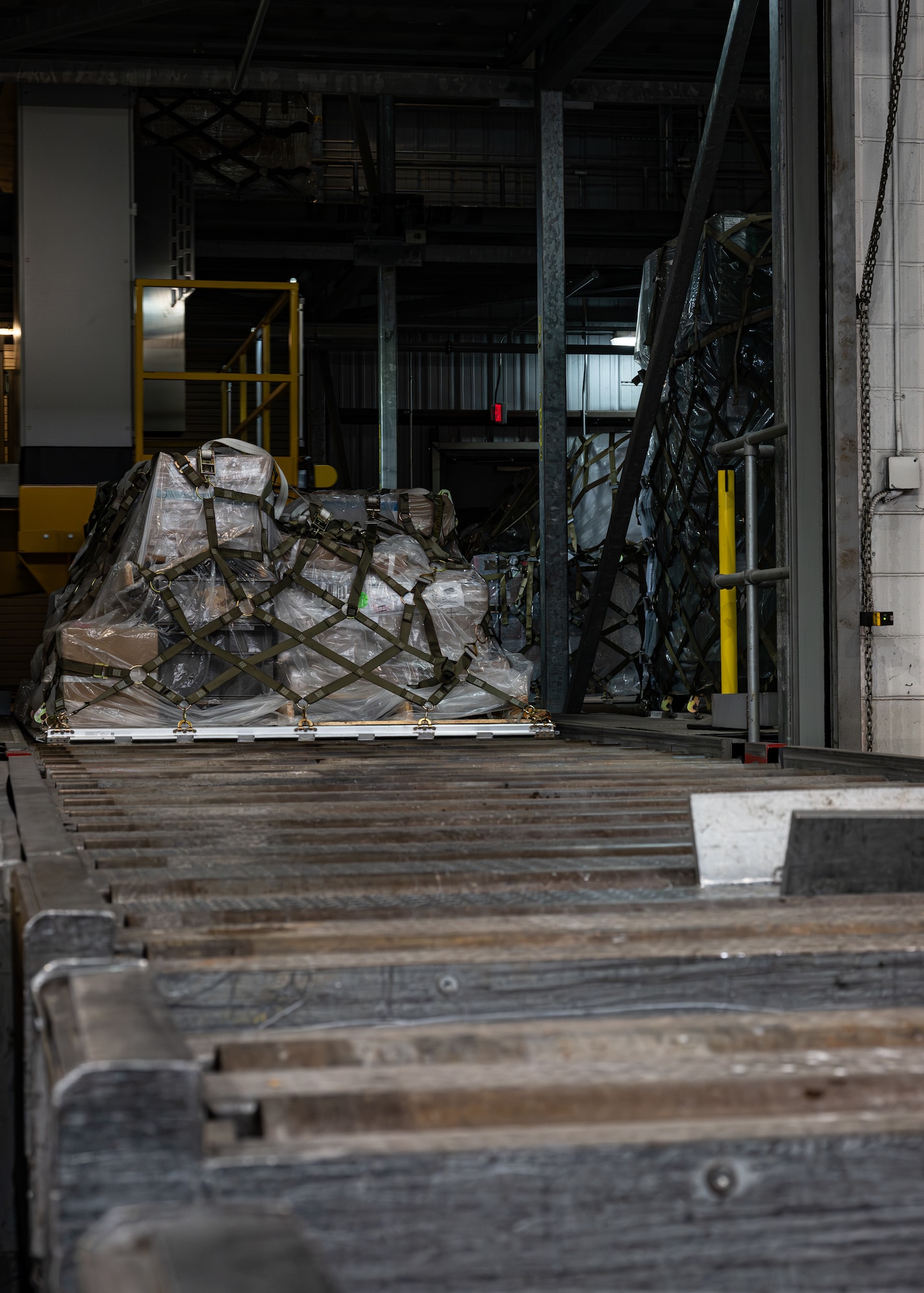 U.S. Air Force palletized cargo sits secured on a roller system inside the 436th Aerial Port Squadron on Dover Air Force Base, Delaware, Feb. 26, 2026. Airmen build, inspect and prepare cargo for loading onto aircraft, enabling rapid worldwide deployment and sustainment operations. (U.S. Air Force photo by Airman 1st Class Macy Dismore-Mann)