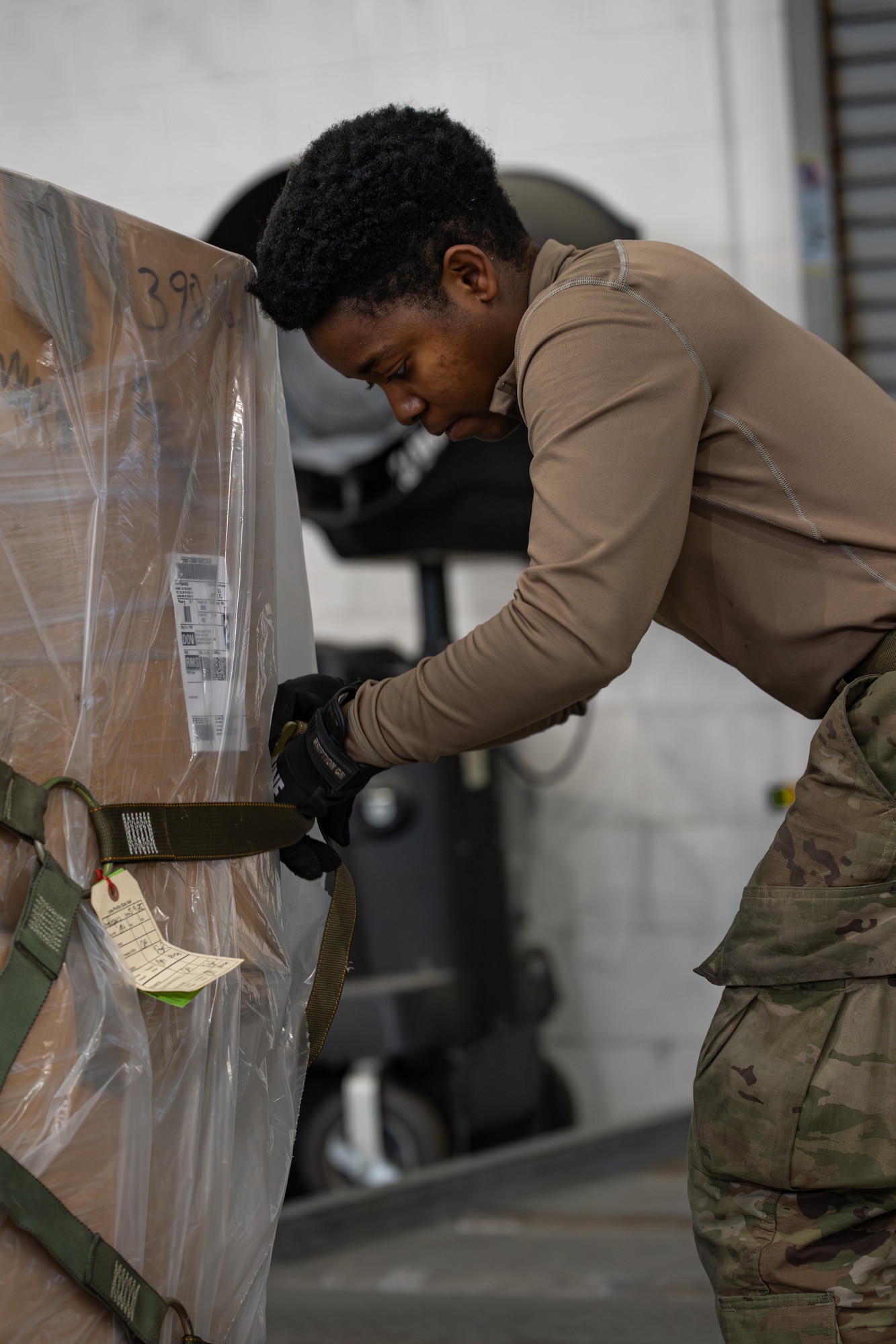 U.S. Air Force Airman 1st Class Kimberly Webb Brown Floyd, 436th Aerial Port Squadron cargo processor, secures cargo to a pallet inside the 436th APS on Dover Air Force Base, Delaware, Feb. 26, 2026. Aerial porters build and inspect cargo to ensure it is properly restrained and prepared for safe airlift operations. (U.S. Air Force photo by Airman 1st Class Macy Dismore-Mann)