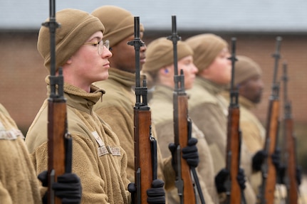 U.S. Air Force Airman 1st Class Isaiah Lolopulos, left, a ceremonial guardsman with the U.S. Air Force Honor Guard Firing Party, stands at the position of attention during training on Joint Base Anacostia-Bolling, Washington, D.C., March 3, 2026. While assigned to the Honor Guard, Airmen in the Firing Party maintain a rigorous training schedule of two to six hours each day and support memorial operations at Arlington National Ceremony. (U.S. Air Force photo by Hayden Hallman)