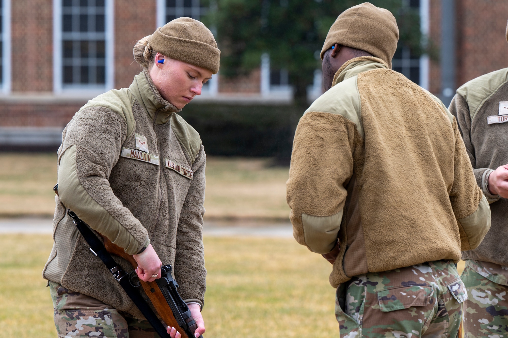 U.S. Air Force Airman 1st Class Kyleigh Mauldin, left, a ceremonial guardsman with the U.S. Air Force Honor Guard Firing Party, demonstrates a clear chamber of an M14 rifle during training on Joint Base Anacostia-Bolling, Washington, D.C., March 3, 2026. The seven-man teams rehearsed firing three rounds in perfect unison to honor the fallen. (U.S. Air Force photo by Hayden Hallman)