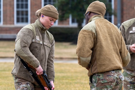 U.S. Air Force Airman 1st Class Kyleigh Mauldin, left, a ceremonial guardsman with the U.S. Air Force Honor Guard Firing Party, demonstrates a clear chamber of an M14 rifle during training on Joint Base Anacostia-Bolling, Washington, D.C., March 3, 2026. The seven-man teams rehearsed firing three rounds in perfect unison to honor the fallen. (U.S. Air Force photo by Hayden Hallman)