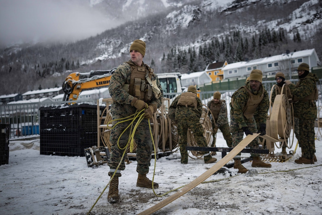 U.S. Marines with 6th Engineer Support Battalion, 4th Marine Logistics Group, Marine Forces Reserve, unroll a three-inch fuel hose in Narvik, Norway, March 4, 2026. The Marines set up the bulk fuel equipment to establish a Joint Petroleum Off-the-Shore operation as part of exercise Cold Response 26. A key component of NATO's enhanced vigilance activity Arctic Sentry, exercise Cold Response 26 is a Norwegian-led winter military exercise designed to enhance collective defense capabilities and ensure U.S. readiness to rapidly deploy and seamlessly operate alongside NATO Allies in challenging arctic conditions. (U.S. Marine Corps photo by Staff Sgt. Scott Jenkins)