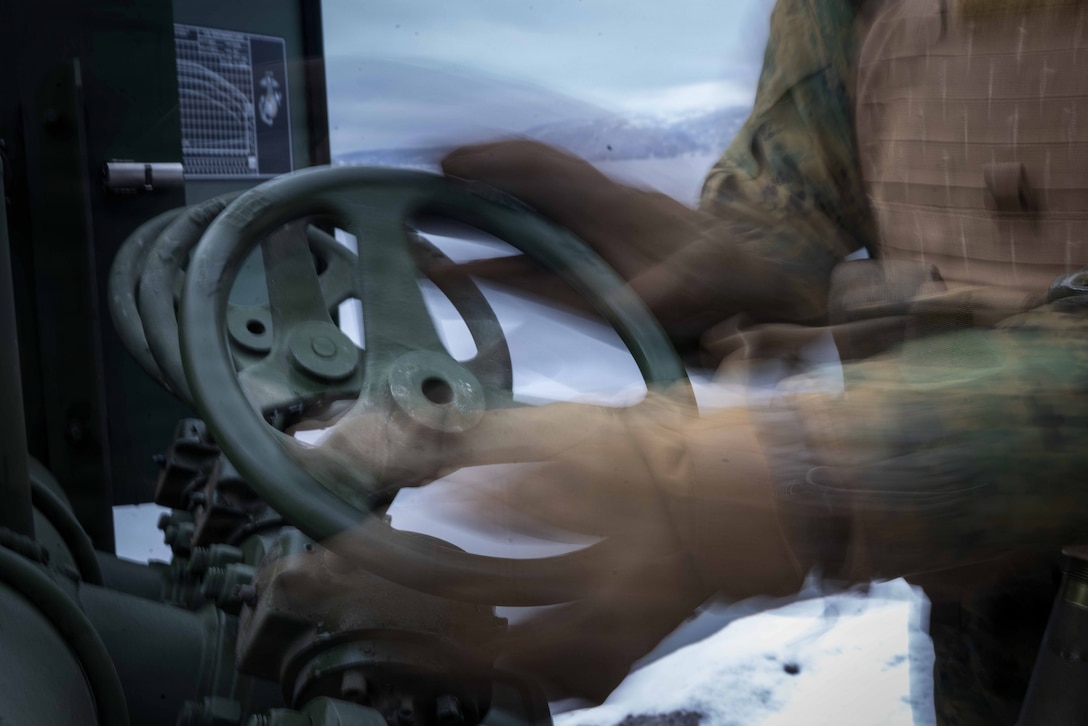 U.S. Marine Corps Cpl. Njomen Usmanjuniorabdulahi, an expeditionary fuels technician with 6th Engineer Support Battalion, 4th Marine Logistics Group, Marine Forces Reserve, opens a gate valve on a 600-gallon-per-minute pump in Narvik, Norway, March 4, 2026. The Marines set up the bulk fuel equipment to establish a Joint Petroleum Off-the-Shore operation as part of exercise Cold Response 26. A key component of NATO's enhanced vigilance activity Arctic Sentry, exercise Cold Response 26 is a Norwegian-led winter military exercise designed to enhance collective defense capabilities and ensure U.S. readiness to rapidly deploy and seamlessly operate alongside NATO Allies in challenging arctic conditions. (U.S. Marine Corps photo by Staff Sgt. Scott Jenkins)