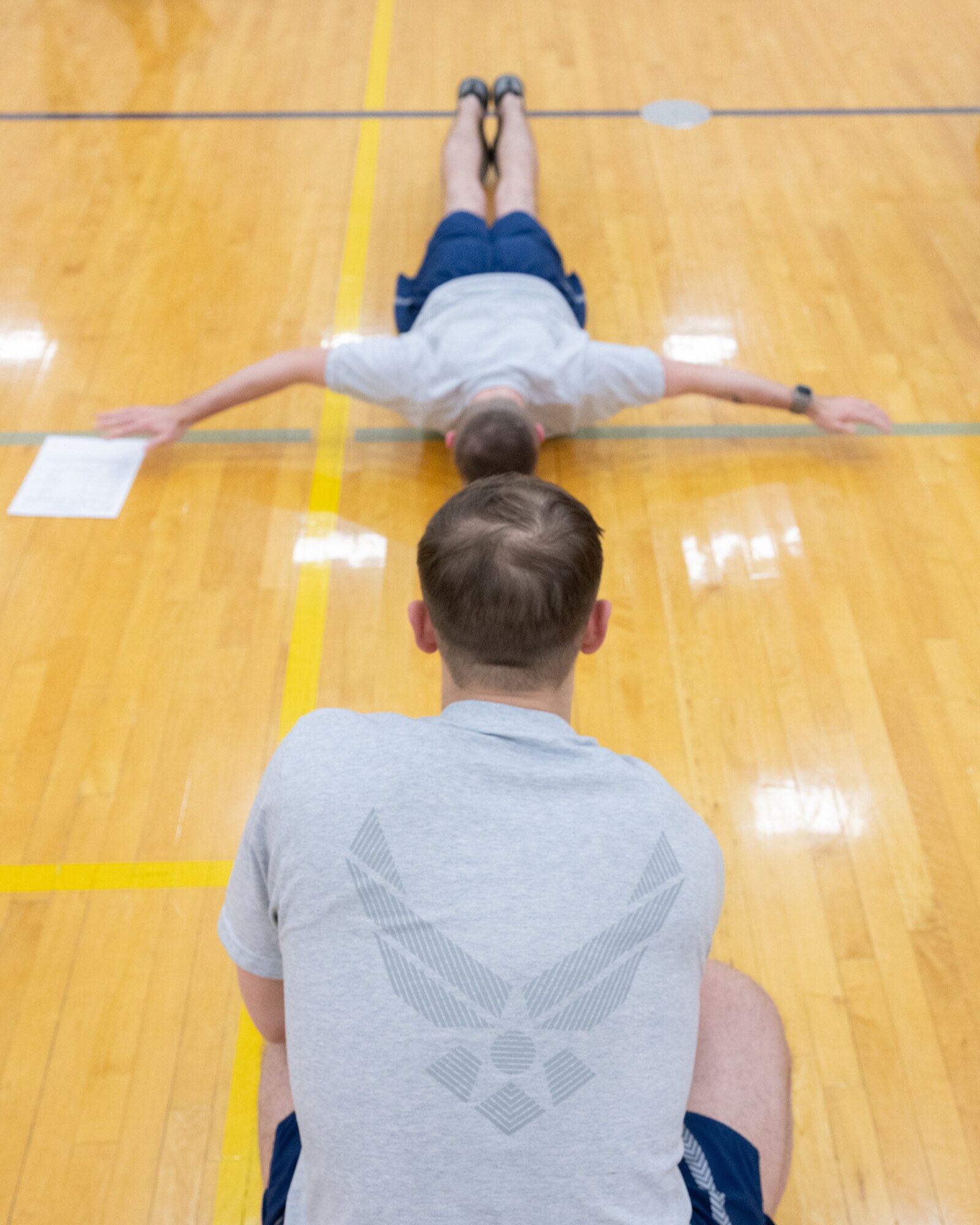 U.S. Air Force Senior Airman Chase Reinhart, 436th Operations Support Squadron radar airfield weather systems trainer, counts a classmate’s hand-release push-ups during a mock fitness test on their first day of Airmen Leadership School at Dover Air Force Base, Delaware, March 2, 2026. Day One of each ALS class consists of a physical fitness test, uniform inspection and briefs by the school commandant and instructors outlining the course. (U.S. Air Force photo by Mauricio Campino)