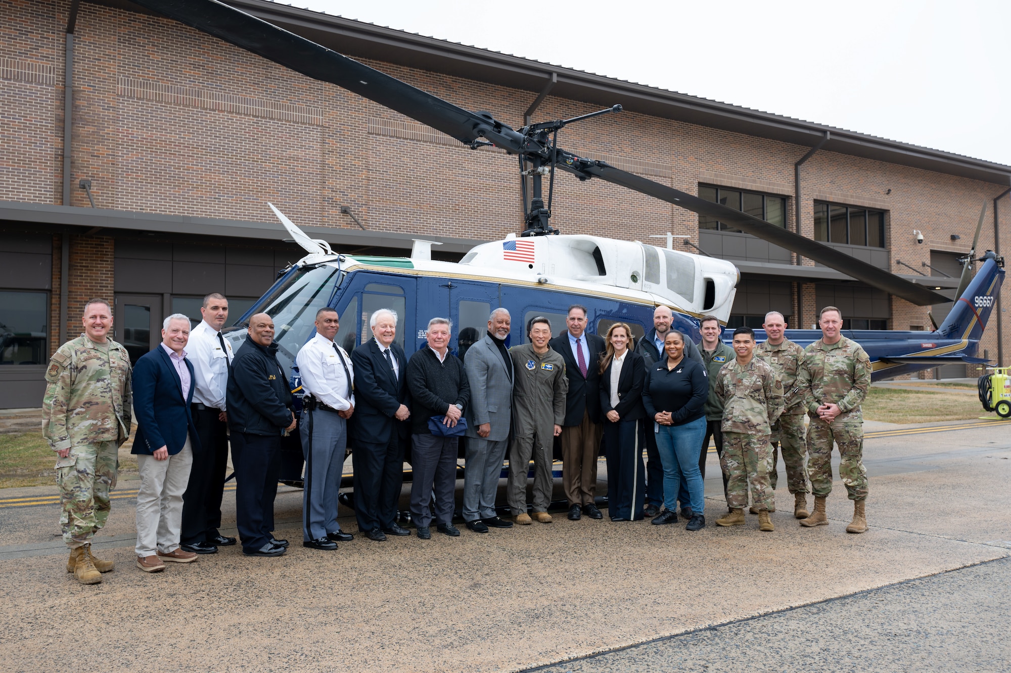 People stand in front of a helicopter.