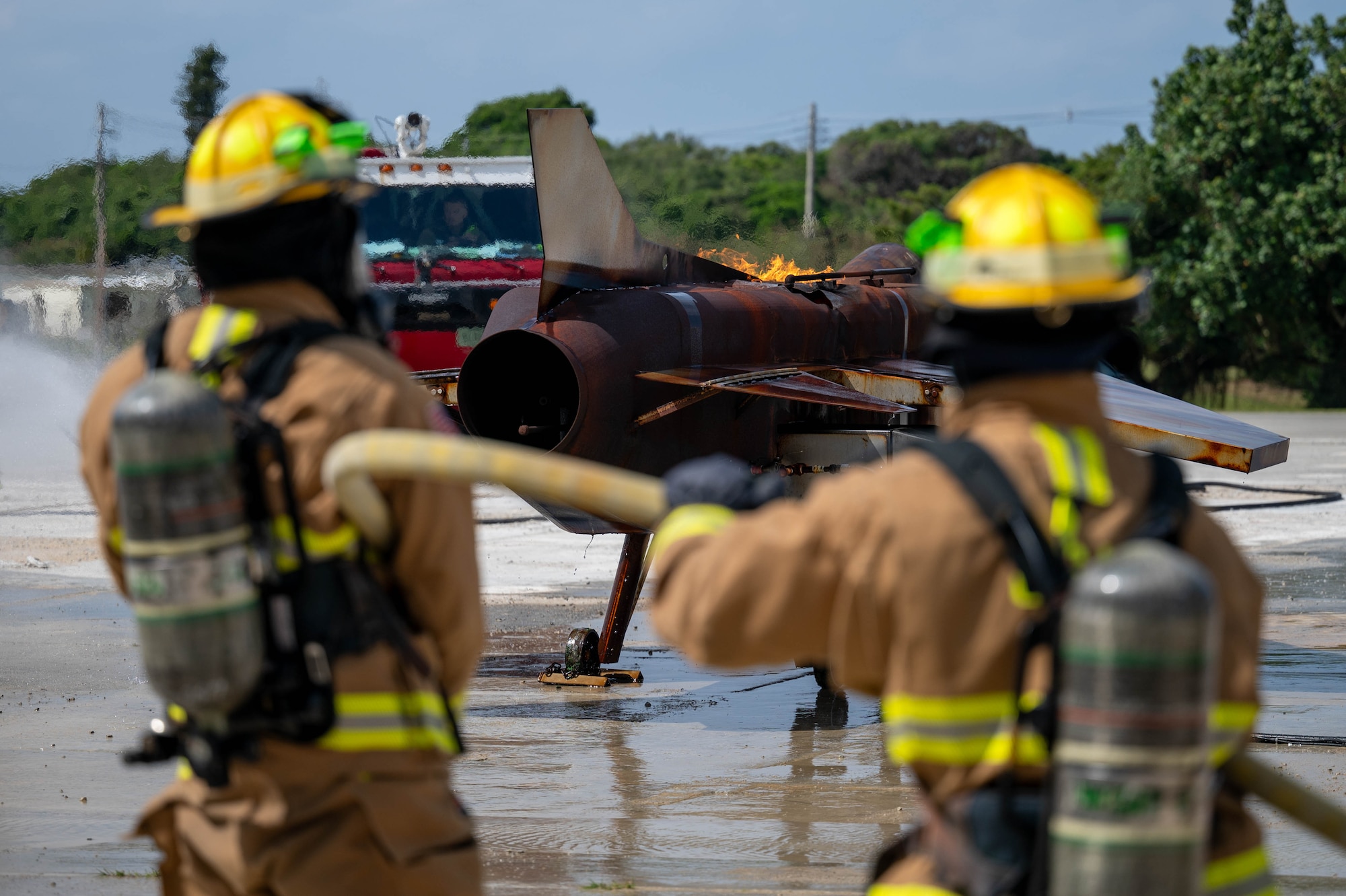 U.S. Air Force 18th Civil Engineer Squadron firefighters spray water on a simulated aircraft during U.S. Air Force-led operational exercise Beverly Midnight 26 at Kadena Air Base, Japan, Mar. 10, 2026. BM26 enhances U.S. interoperability by fostering an exchange of information and refining shared tactics, techniques and procedures to better integrate defense capabilities in support of regional security. (U.S. Air Force photo by Airman 1st Class Francisco Huerta)