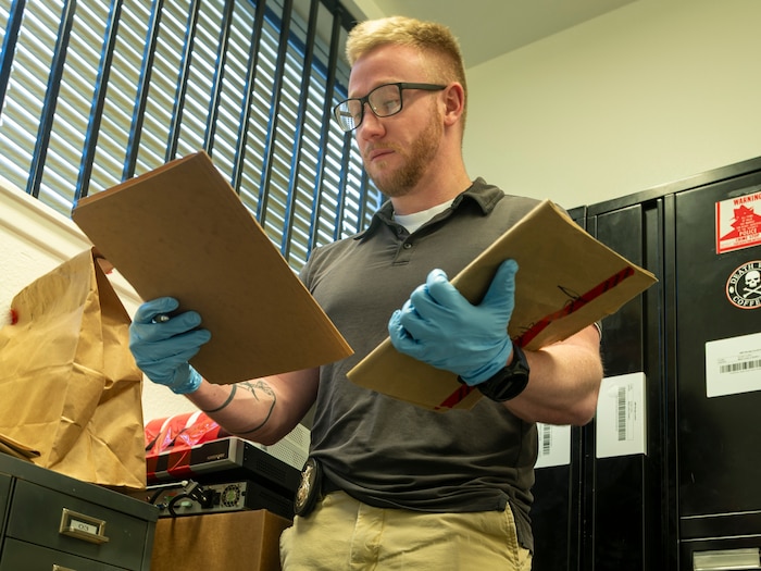 Investigator Jacob Trafton, 412th Security Forces Squadron, analyzes evidence confiscated from four dispensaries selling psilocybin mushrooms. The raids led to the closure of the businesses and the arrest of nine people on suspicion of maintaining a place for drug sales, possession of marijuana for sale and conspiracy. (Photo by Laisa Leao)