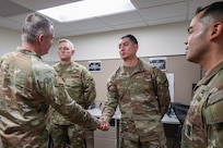 Lt. Gen. Christopher O. Mohan, U.S. Army Materiel Command commanding general, left, presents a coin to Sgt. Ryan A. Perchez, 45th Finance Center senior information technical specialist, center right, after presenting one to Sgt. 1st Class Nathan L. James, 45th FC internal control advisor, center left, as Maj. Danny Duarte, 45th FC Team A officer in change, looks on at Fort Knox, Ky., March 4, 2026. In his role, Perchez is responsible for advising commanders and staff on the planning, integration and execution of financial management information systems in support of the U.S. Central Command and Continental United States areas of responsibility. (U.S. Army photo by Pvt. 1st Class Arpita Singh)