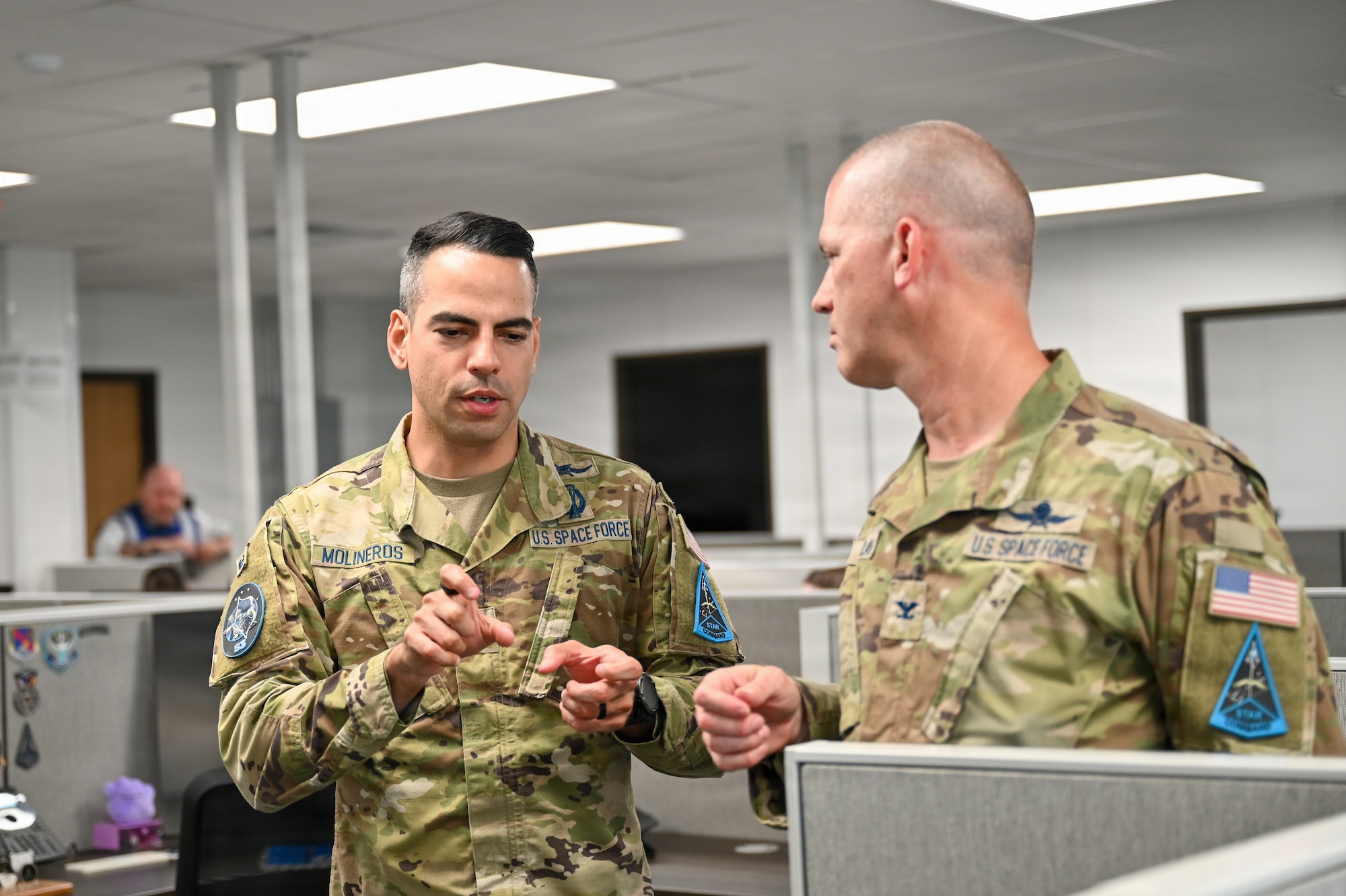 Two Guardians in uniform talk in an office space