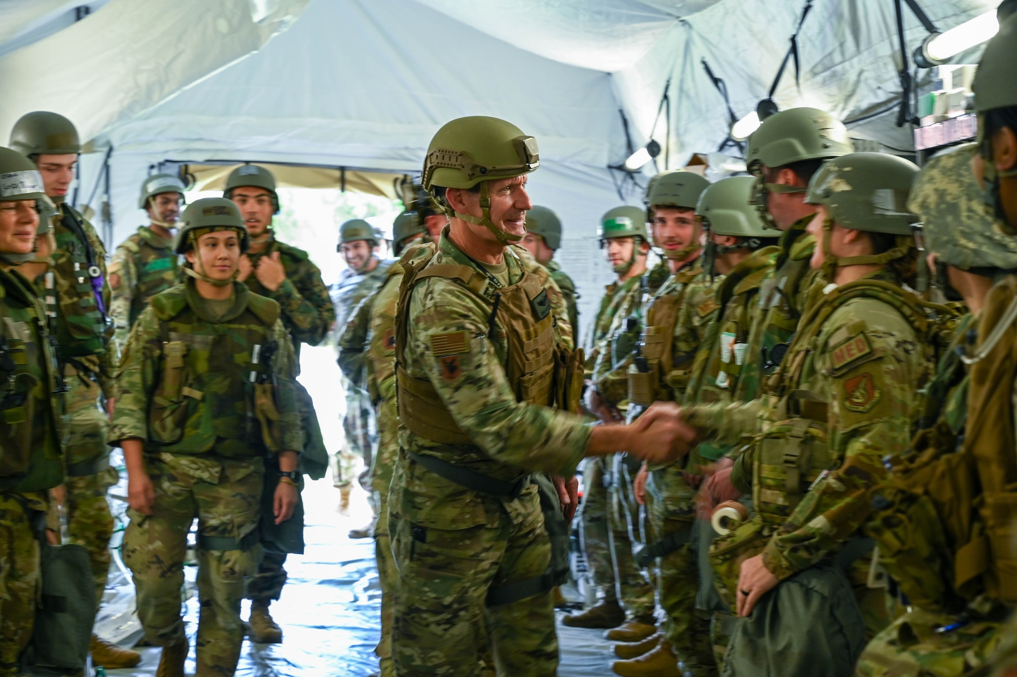 U.S. Air Force Brig. Gen. John Gallemore, 18th Wing Commander, greets Airmen assigned to the 18th Medical Group during a USAF-led operational exercise Beverley Midnight 26 at Kadena Air Base, Japan, March 10, 2026. This exercise provides unique opportunities to synchronize and integrate various forces across Japan into joint, coalition and bilateral training from simulated forward operating bases. (U.S. Air Force photo by Airman 1st Class Amy Kelley)