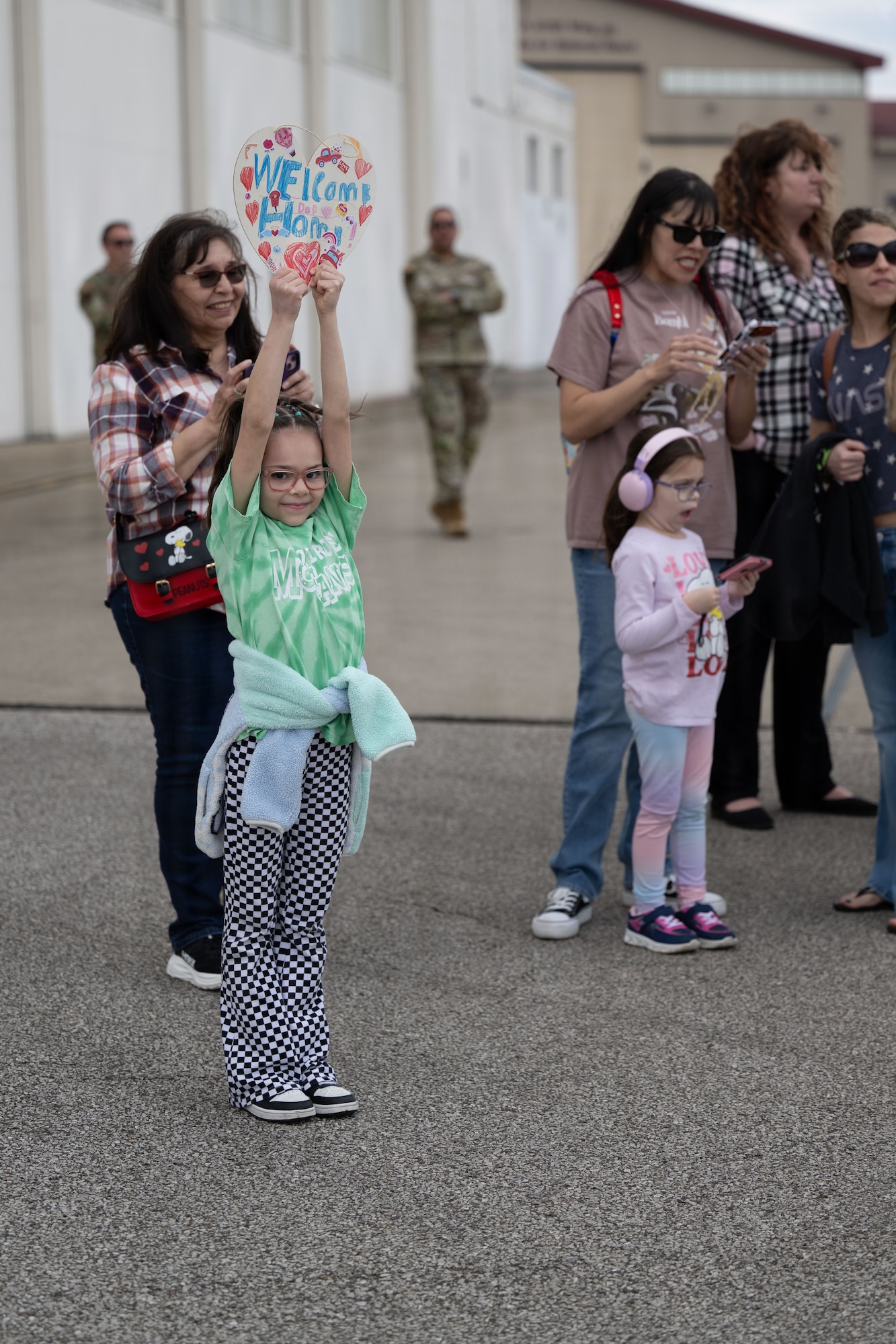 Family members of airmen assigned to the 130th Airlift Wing wait for an aircraft to land in Charleston, W.Va., March 5, 2026. Approximately 120 Airmen from the 130th Airlift Wing are returning home after a historic deployment to the Horn of Africa, the unit’s first mission since transitioning to the C-130J-30 Super Hercules. (U.S. Air National Guard photo by Staff Sgt. Takara Williams)